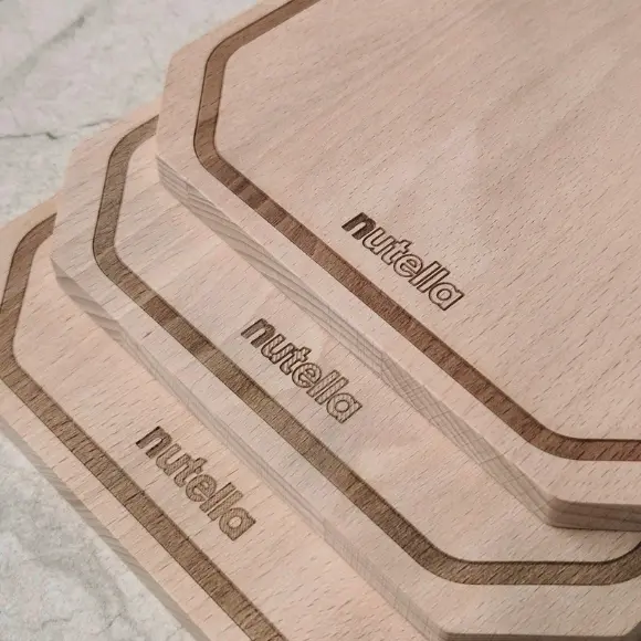 Stos desek drewnianych z logo Nutella – seryjne grawerowanie laserowe, idealna deska drewniana z grawerem dla marki,Stack of wooden boards with the Nutella logo – serial laser engraving, the perfect wooden board with engraving for the brand