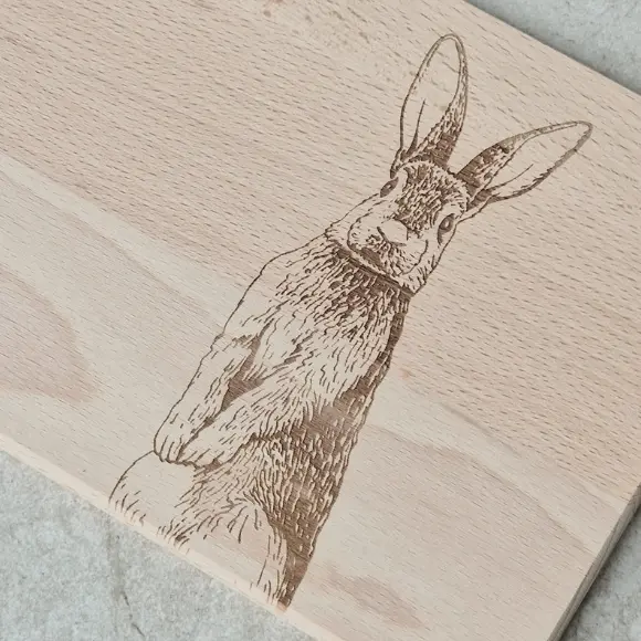Artystyczny grawer zająca na desce do krojenia – polski producent oferuje detaliczne grawerowanie laserowe w drewnie, Artistic engraving of a hare on a cutting board – Polish manufacturer offers retail laser engraving on wood