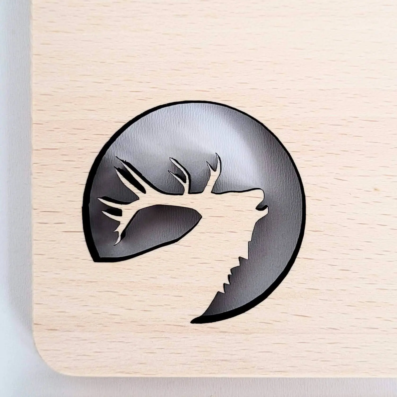 Profil głowy jelenia z porożem, gdzie gładkie, jasne drewno wycinane laserowo odsłania ciemne tło, demonstrując kreatywne zastosowanie wycinania laserowego drewna w dekoracji,A deer head profile with horns, where smooth, light wood laser cut reveals a dark background, demonstrating the creative use of laser cutting wood in decoration