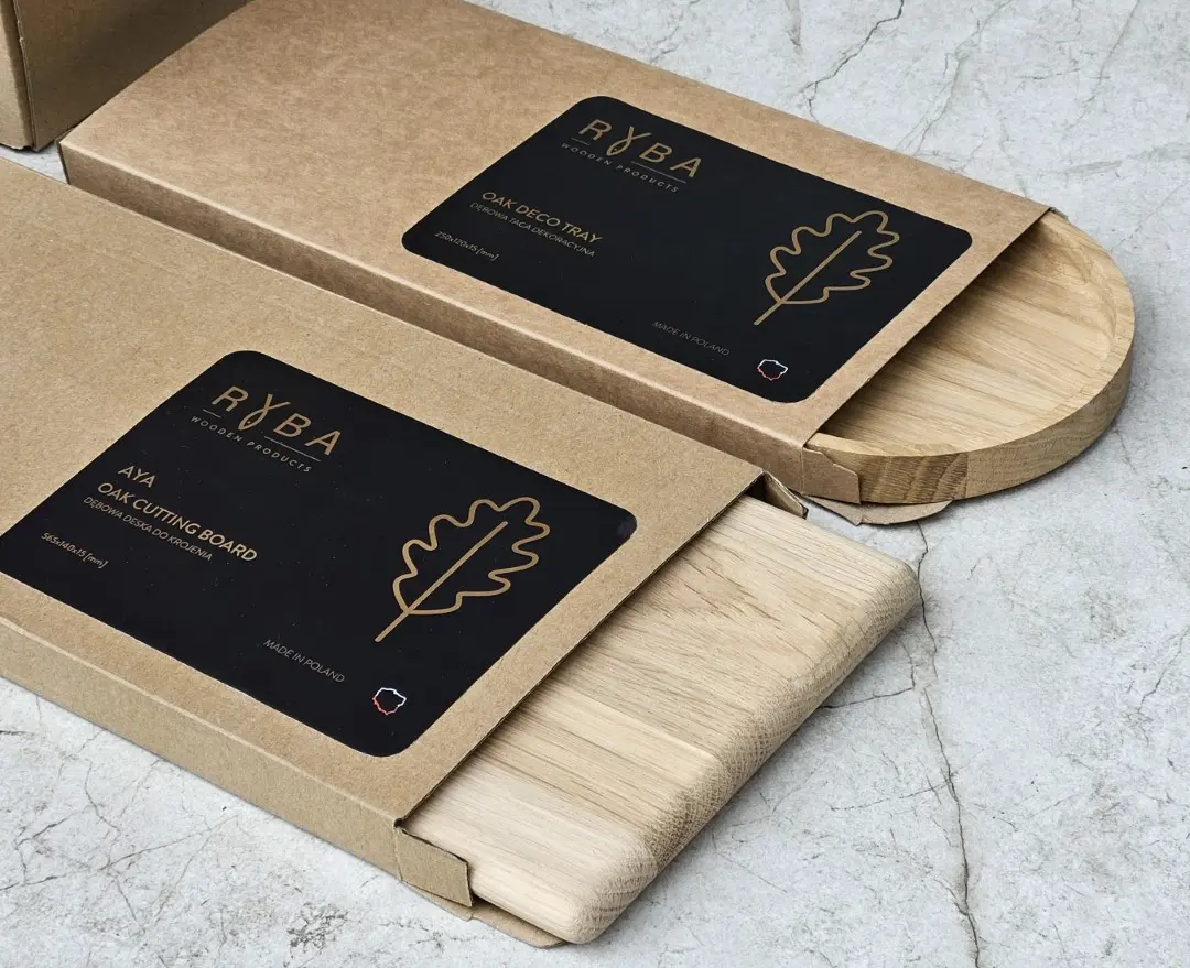Dębowe deski wysuwane z eleganckich pudełek kartonowych z czarną etykietą -producent desek do krojenia,Oak boards sliding out of elegant cardboard boxes with black labels – manufacturer of cutting boards