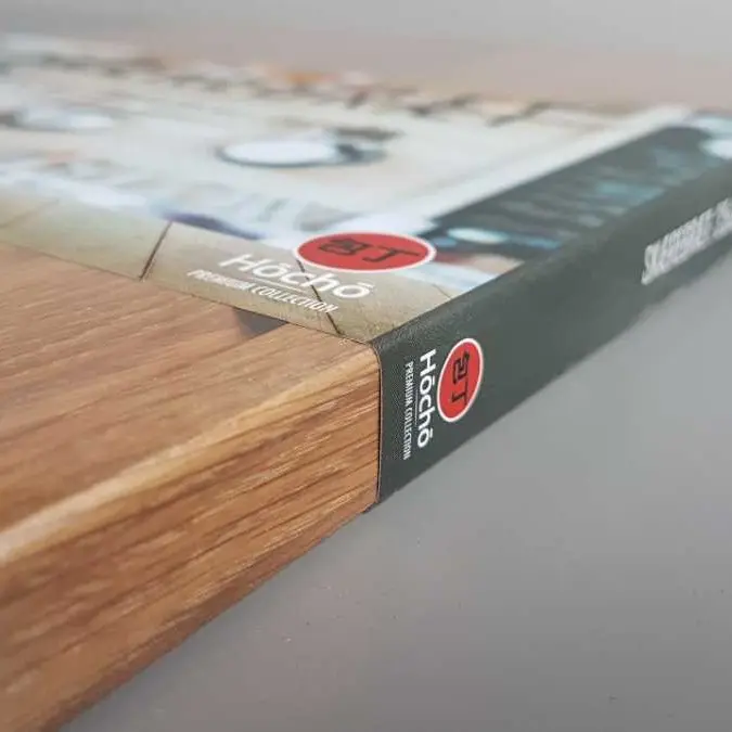 Dębowa deska premium, na której znajduje się papierowa banderola reklamowa marki,produkt z marketingową etykietą podkreślającą wysoką jakość wykonania